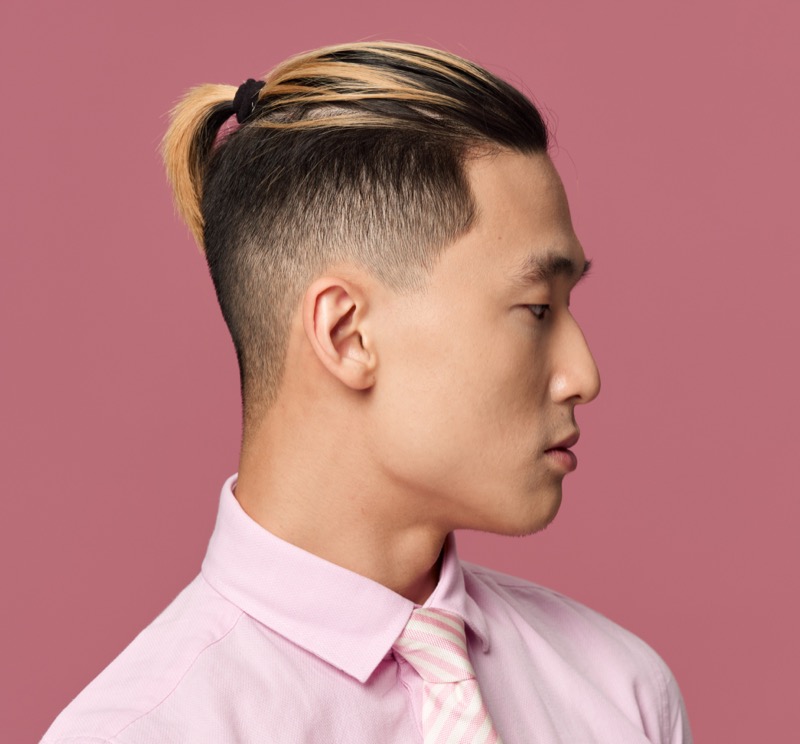 The top knot with a burst fade blends tradition with a bold, modern edge.